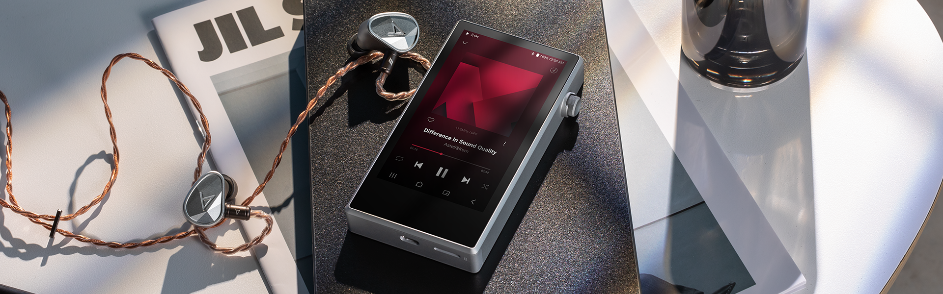 Astell&Kern PD5 in Silver with in-ear monitors on a sunlit table